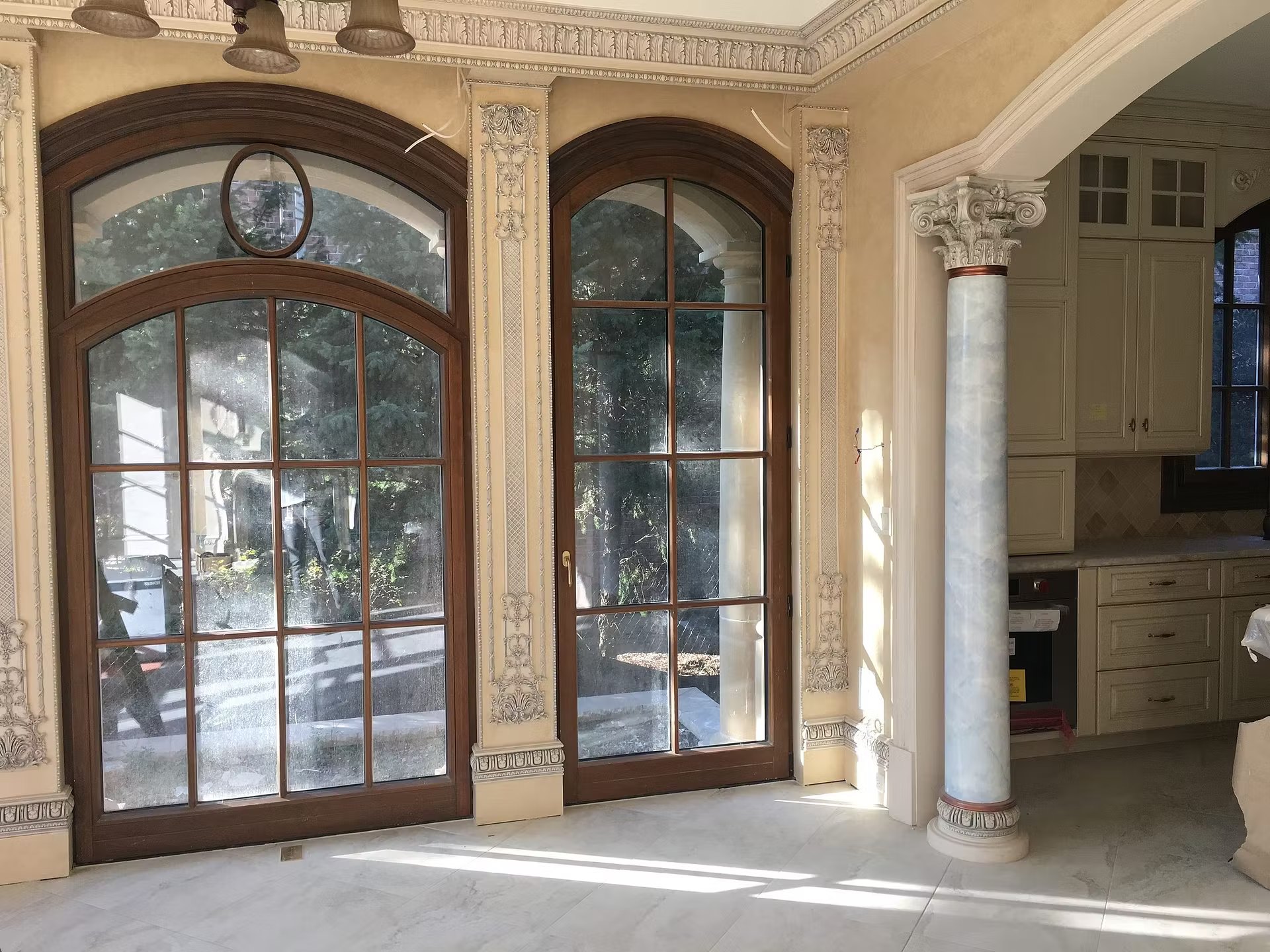 Arched wood French doors between stone pilasters