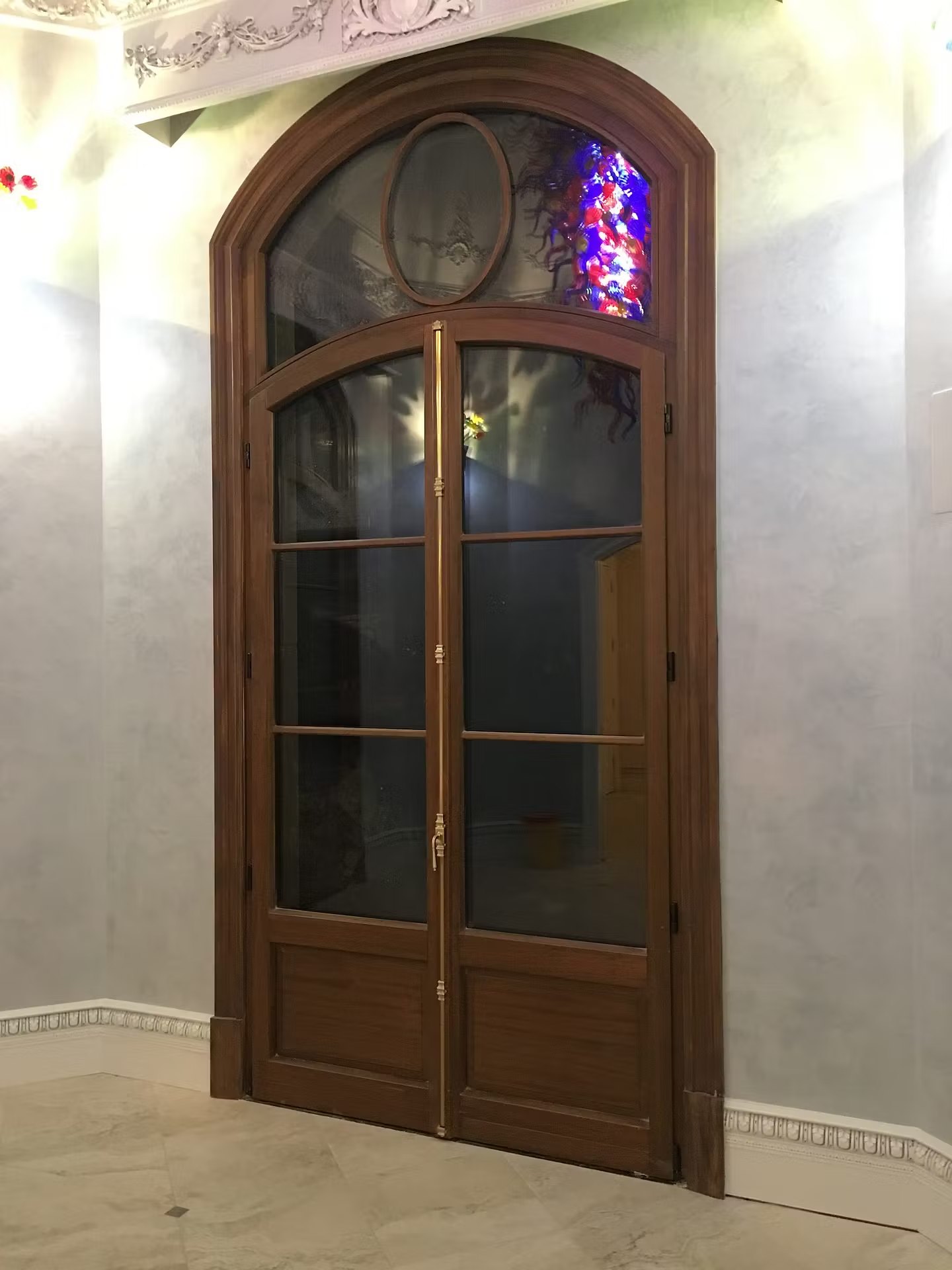 Tall mahogany French door with oval transom